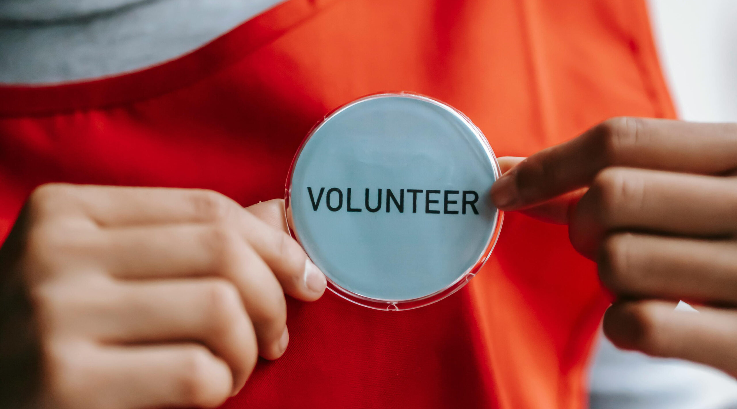 Volunteer Person holding badge to volunteer in Louisville, KY